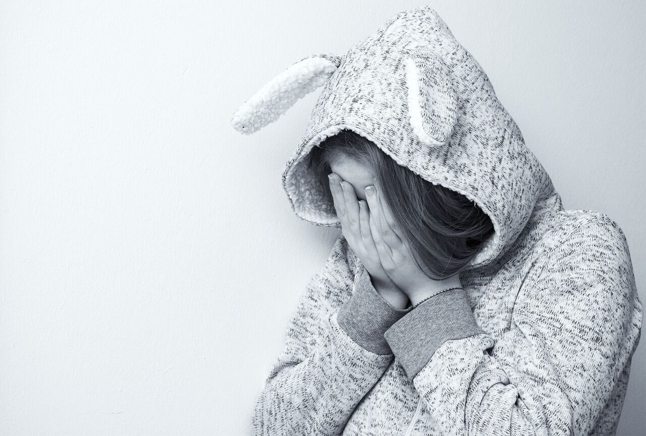 A woman looking melancholic, representing emotional symptoms of depression.